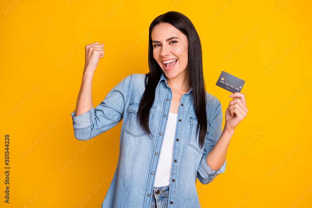 Close-up portrait of nice attractive lovely pretty cute cheerful cheery girl holding in hand cell plastic card new solution novelty advert isolated bright vivid shine vibrant yellow color background - obrazy, fototapety, plakaty 