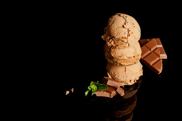 fresh delicious chocolate ice cream with mint leaves isolated on black