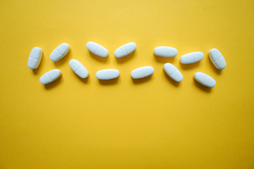 Wall Mural - White pills  on a colorful background with a free area for text