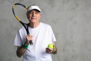 Wall Mural - Cheerful senior tennis player wearing a visor cap
