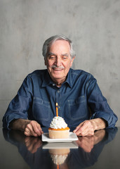 Poster - Senior man celebrating with a birthday cupcake