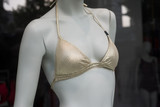 Fototapeta Sypialnia - closeup of golden bikini on mannequin in fashion store showroom for women