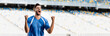 © LIGHTFIELD STUDIOS - emotional professional soccer player in blue and white uniform showing yes gesture at stadium, panoramic shot