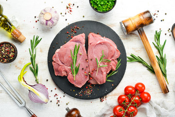 Raw veal meat. Two raw steaks with spices. Top view. Free space for your text.