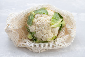 Poster - fresh cauliflower with reusable bag on ceramic background