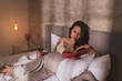 © Impact Photography - Pregnant woman reading a book in bed