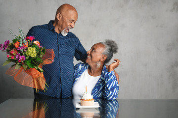 Wall Mural - African American couple celebrating an anniversary together with flowers