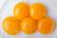 Top View And Closeup Of Five Separated Yolk Eggs In The Bowl As A Background