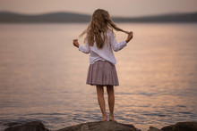 Back View. Sweet Girl With Long Hair Standing On A Rock On The Lake. Concepts Of Harmony, Peaceful And Happiness Of Childhood Within Vacations.