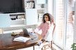© LIGHTFIELD STUDIOS - happy african american freelancer holding cup while using laptop at home