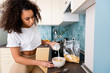 © LIGHTFIELD STUDIOS - african american woman pouring milk in bowl with cornflakes