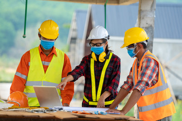 Aufkleber - Builders wearing safety helmet with blueprint at construction,Concept of residential building under construction.