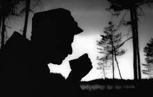 Black Outline Of A Military Man Drinking From A Mug In The Woods.Finnish Soldier.