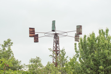 Home made wind generator from barrels in courtyard of house. An eco-friendly home source for the village from barrels