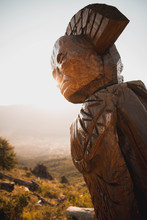 Escultura Tallada De Hombre Nativo En El Sur Argentino Iluminado Por La Puesta Del Sol