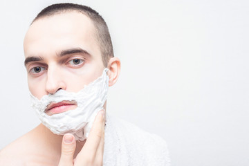 Man with shaving foam on his face, white background, 16:9, copy space