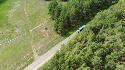 Wall Mural - Commercial truck leaves the forest on the rural road