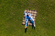 © F8  \ Suport Ukraine - Holidays, vacation, love and friendship concept. Smiling teen couple lying on blanket and looking at each other in park. Top view with copy space