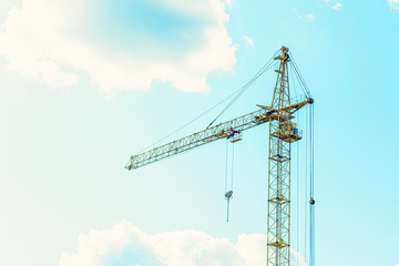 Wall Mural - construction crane on blue sky background with clouds, copy space