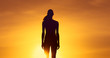 © kieferpix - Silhouette of female standing facing sunset.