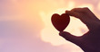 © kieferpix - Hand holding heart against sunset sky. Love concept.