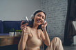 © Viacheslav Yakobchuk - Joyful young woman drinking wine and listening to music