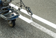 Automated painting by airbrushing of a road using spraying for driving direction, road repair marking on asphalt pavement