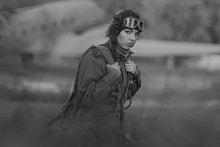 Retro Style Black And White. A Young Female Pilot In Uniform Of Soviet Army Pilots During The World War II. Military Shirt With Shoulder Straps Of A Major, Parachute, Flight Helmet And Goggles.