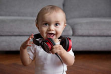 Happy Baby Wearing Headphones Around Neck