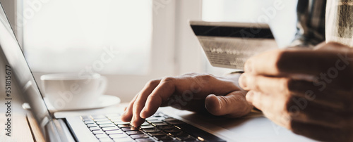 Fotografía Man hand holding credit card and using laptop at home, Businessman or entreprene