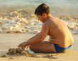 © schankz - A boy plays in the sand on the seashore