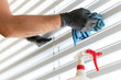 © makasana photo - caucasian man cleaning professionally cleaning window blinds with a micro fiber cloth and cleaning detergent