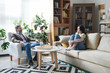 © pressmaster - Young troubled female in casualwear sitting on couch in office of counselor
