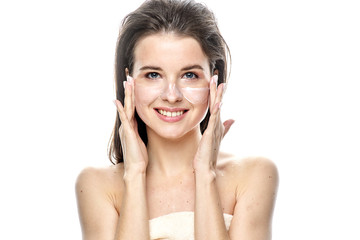 girl with clean skin apply cream on her face. Isolated on a white background