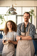© pressmaster - Two young cheerful owners of contemporary restaurant or cafe