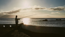 Man Fishing At Sunset