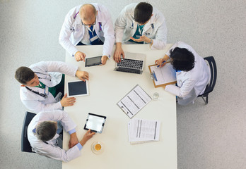 Medical team sitting and discussing at table, top view