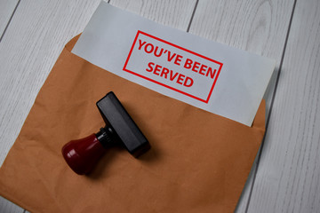 Red Handle Rubber Stamper and You've Been Served text isolated on the table.