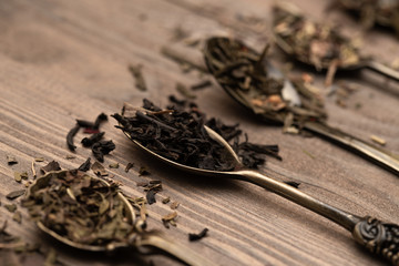 Dried black and green tea leaves on vintage spoons