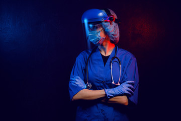 Wall Mural - female doctor in medical mask on the face and gloves on a dark background