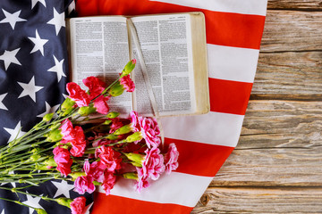 Wall Mural - US flag with praying over a open reading Holy Bible on a close up of america pray