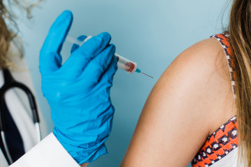 female health care worker administering a shot vaccination for a child