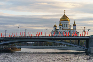 Wall Mural - Moscow cityscape in the spring day.  Cathedral of Christ the Saviour. Coronavirus pandemic time. Nobody. Bolshoy Kamenny Bridge is decorated by red flags by the Victory Day celebration on May 9