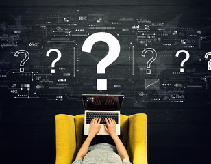 Wall Mural - Question marks with person using a laptop in a chair
