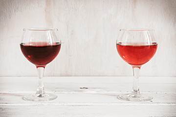 Wall Mural - Red and rose wine in glasses on a white rustic wooden table. Place for text.