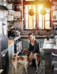 Mature woman cheered by two dogs paying her a friendly visit in a rural house