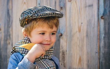 Wall Mural - Autumn. The boy holds a yellow leaf from a tree. Walk in nature. Hello September.