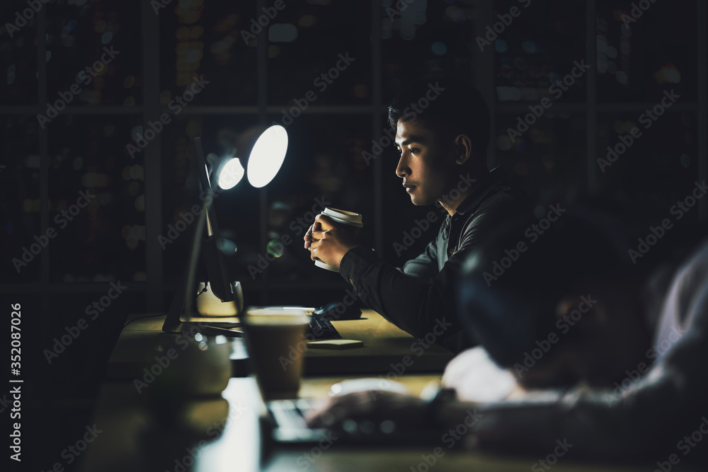 Asian businessman working hard late with his technology laptop in office - obrazy, fototapety, plakaty 