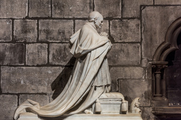 Marble statue of famous person inside of the Notre-Dame de Paris before the big fire, a medieval Catholic cathedral on the Ile de la Cite in the 4th arrondissement of Paris.