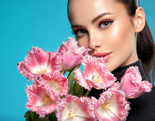 Wall Mural - Beautiful white girl with flowers. Stunning brunette girl with big bouquet flowers of pink tulips. Pretty woman with bright makeup